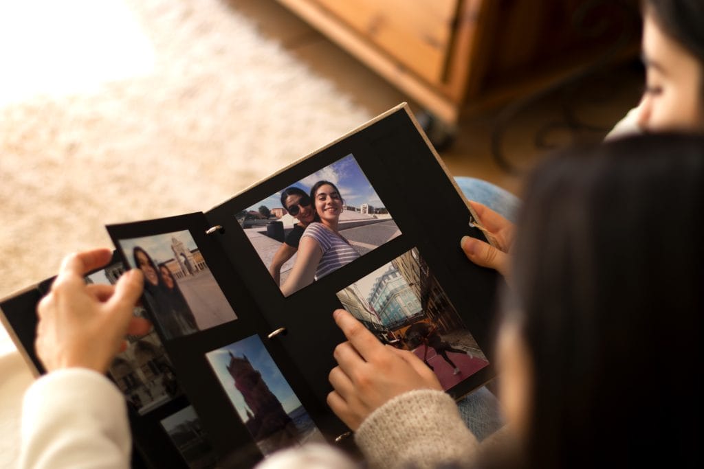 Mãe e filha assistindo a um álbum de fotos de si mesmas
