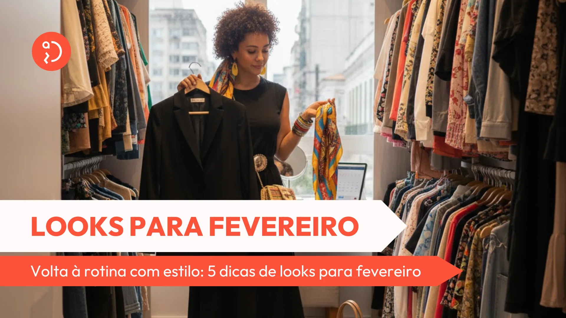 Uma mulher jovem de cabelos cacheados aparece dentro de um closet planejado e organizado, segurando um cabide com um blazer preto estruturado em uma mão e um lenço estampado colorido na outra. Ela veste um vestido preto midi, sandálias com pompons e uma bolsa de palha, demonstrando a escolha de um look volta à rotina que une sobriedade e toques de personalidade. Ao fundo, as araras exibem roupas arrumadas por cores e uma janela revela a vista de prédios urbanos, reforçando o clima de retorno ao trabalho e ao dia a dia na cidade.